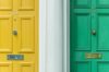 Yellow and green front doors of a house that has recently been purchased.