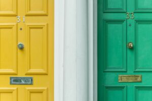 Yellow and green front doors of a house that has recently been purchased.